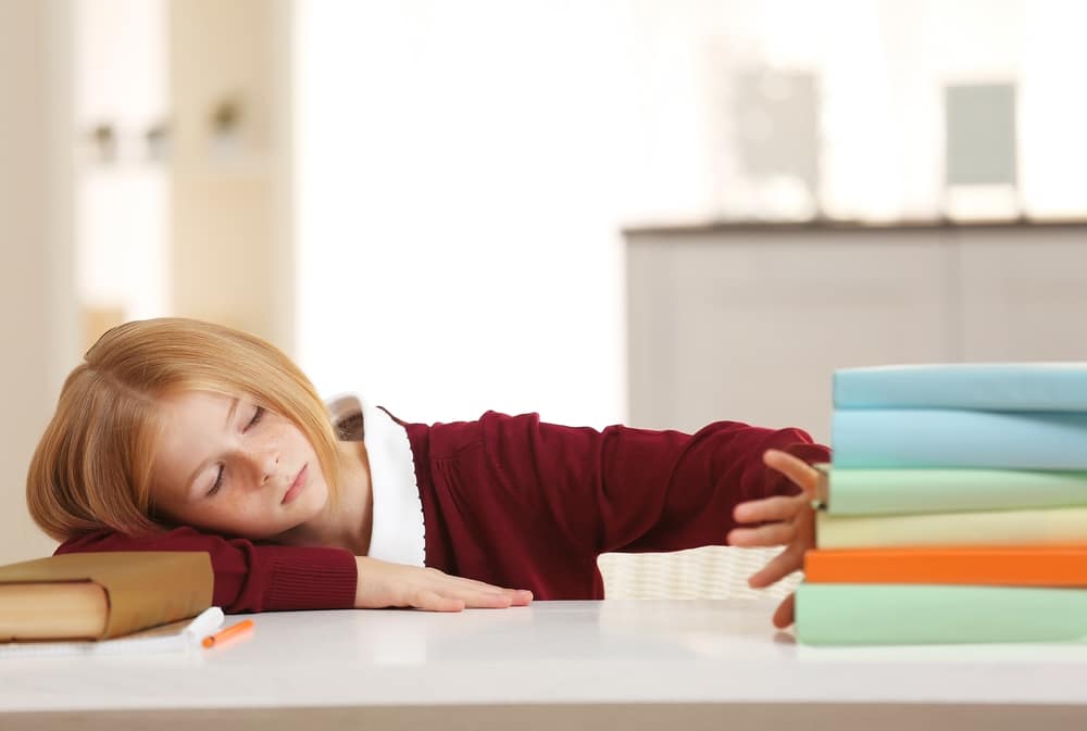 Schoolgirl tired of doing lessons at home Depositphotos 133987374 m 2015